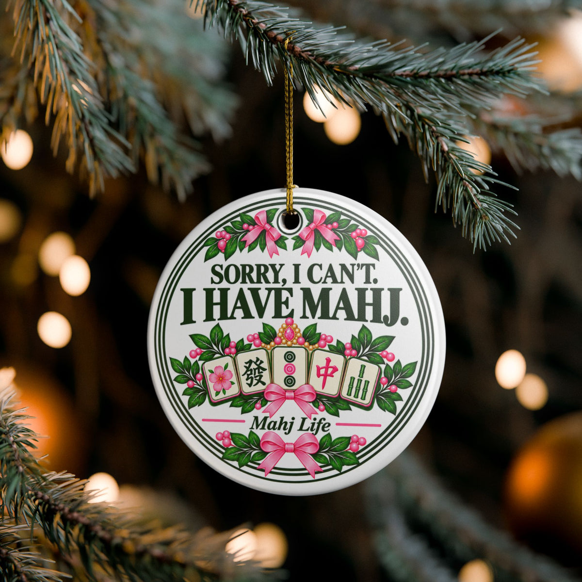 Sorry I Can't I Have Mahj ceramic Christmas ornament hanging on a tree with pink bows and mahjong tiles