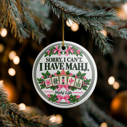 Sorry I Can't I Have Mahj ceramic Christmas ornament hanging on a tree with pink bows and mahjong tiles